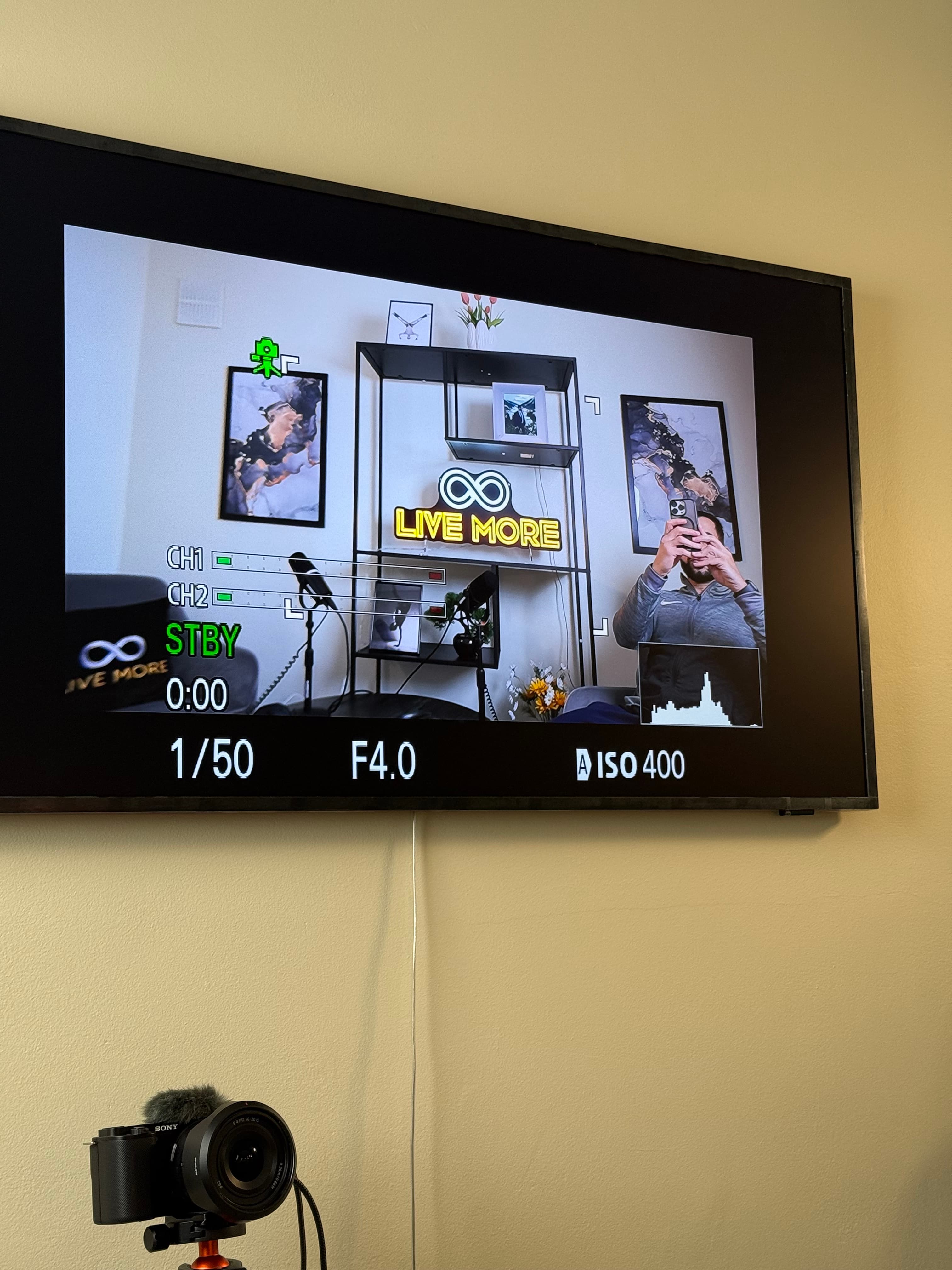 Monitor displaying a camera's live feed and settings next to a wall-mounted camera.